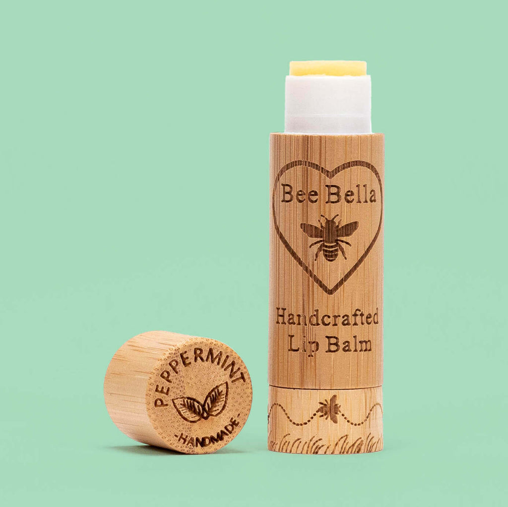 Bee Bella Peppermint Lip balm shown in a bamboo Tube with a green peppermint colored background
